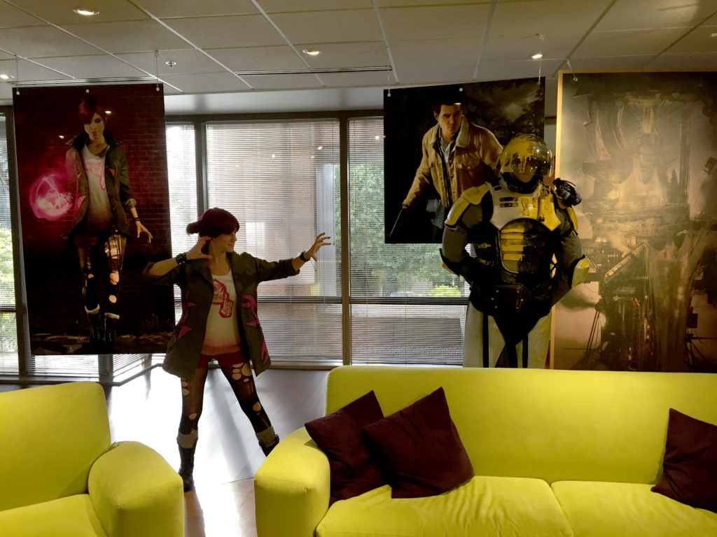 Me dressed as Fetch in Sucker Punch Productions studio with posters of Fetch and Reggie, and a mannequin wearing full D.U.P. armor.